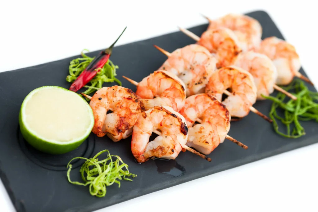 Skewered prawns Yakitori with sauce and limes