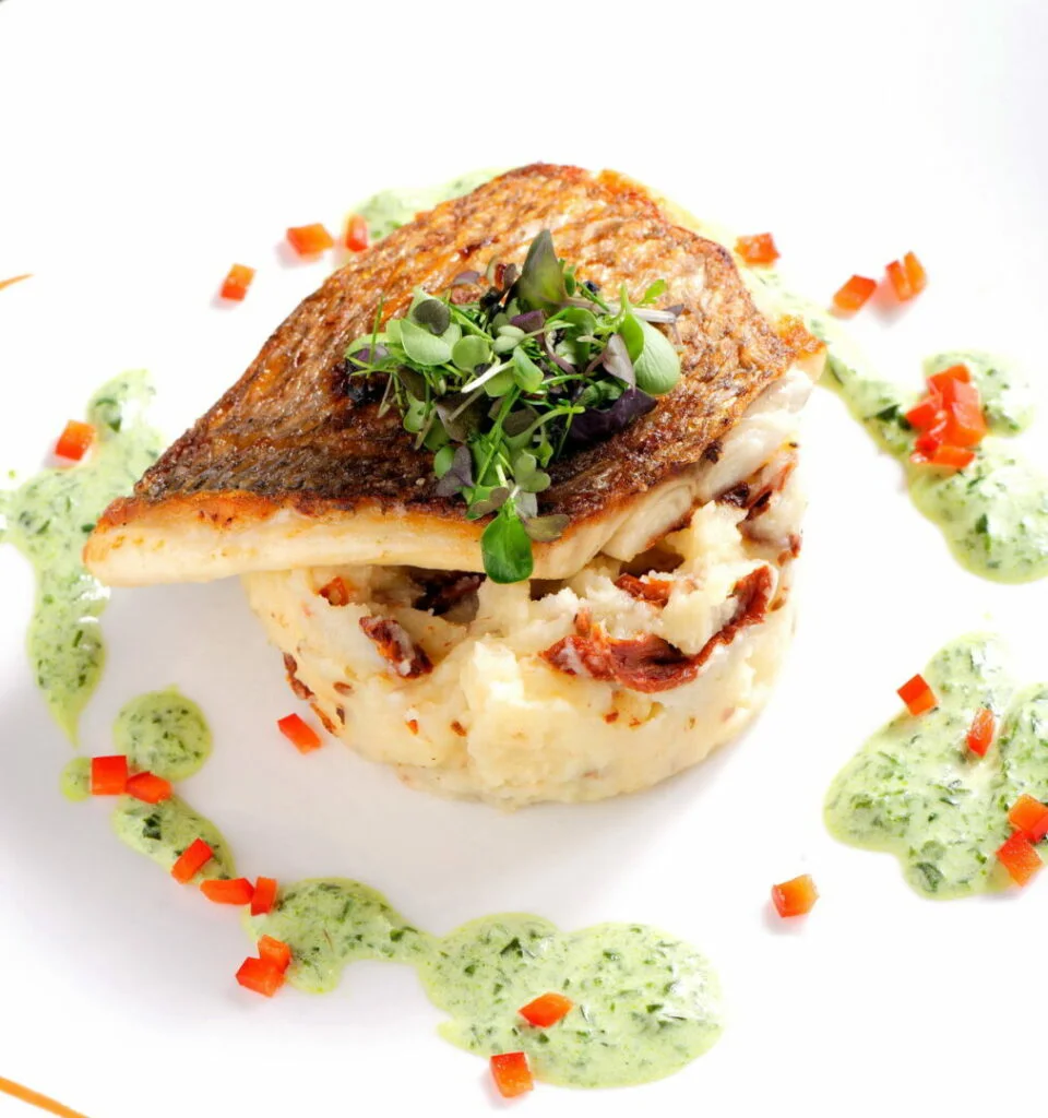 tasty healthy fish fillet with potato puree with dried tomatoes and wild garlic sauce