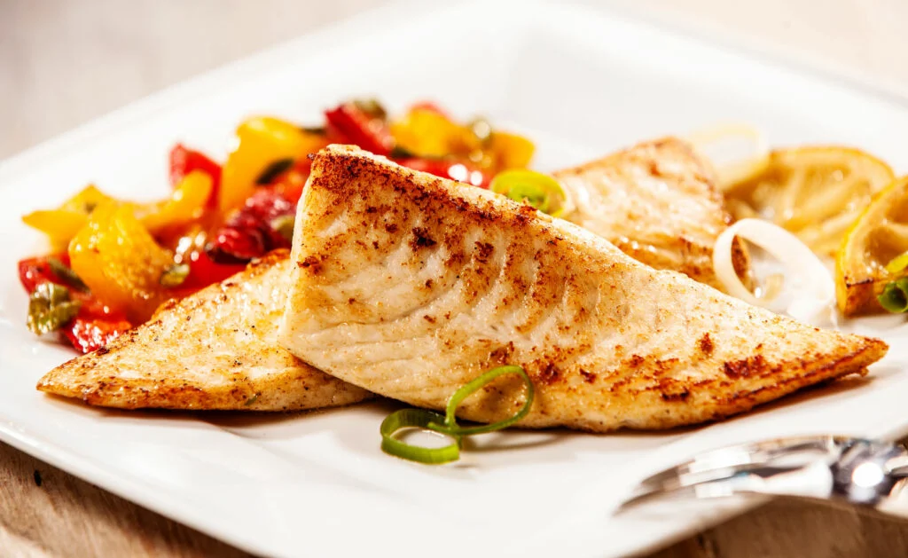 Two marinated grilled fresh Tilapia with peppers