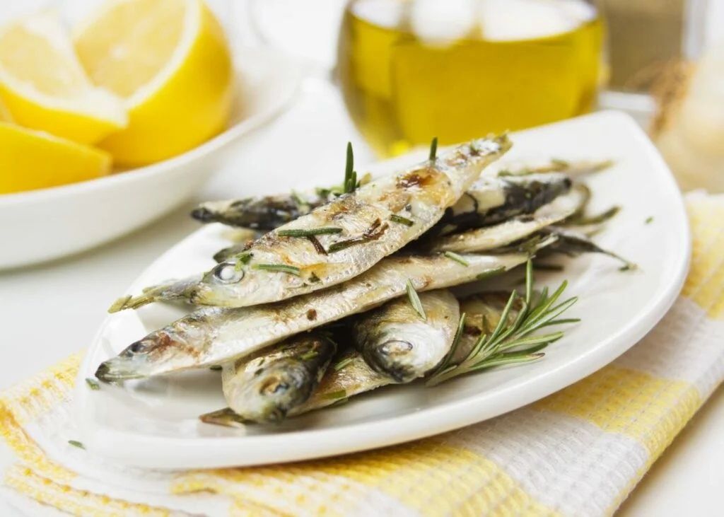 Grilled sardine fish served with lemon and rosemary