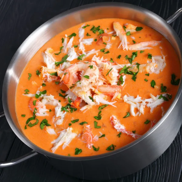 Bisque with lobster head meat in a pot of tomato bisque